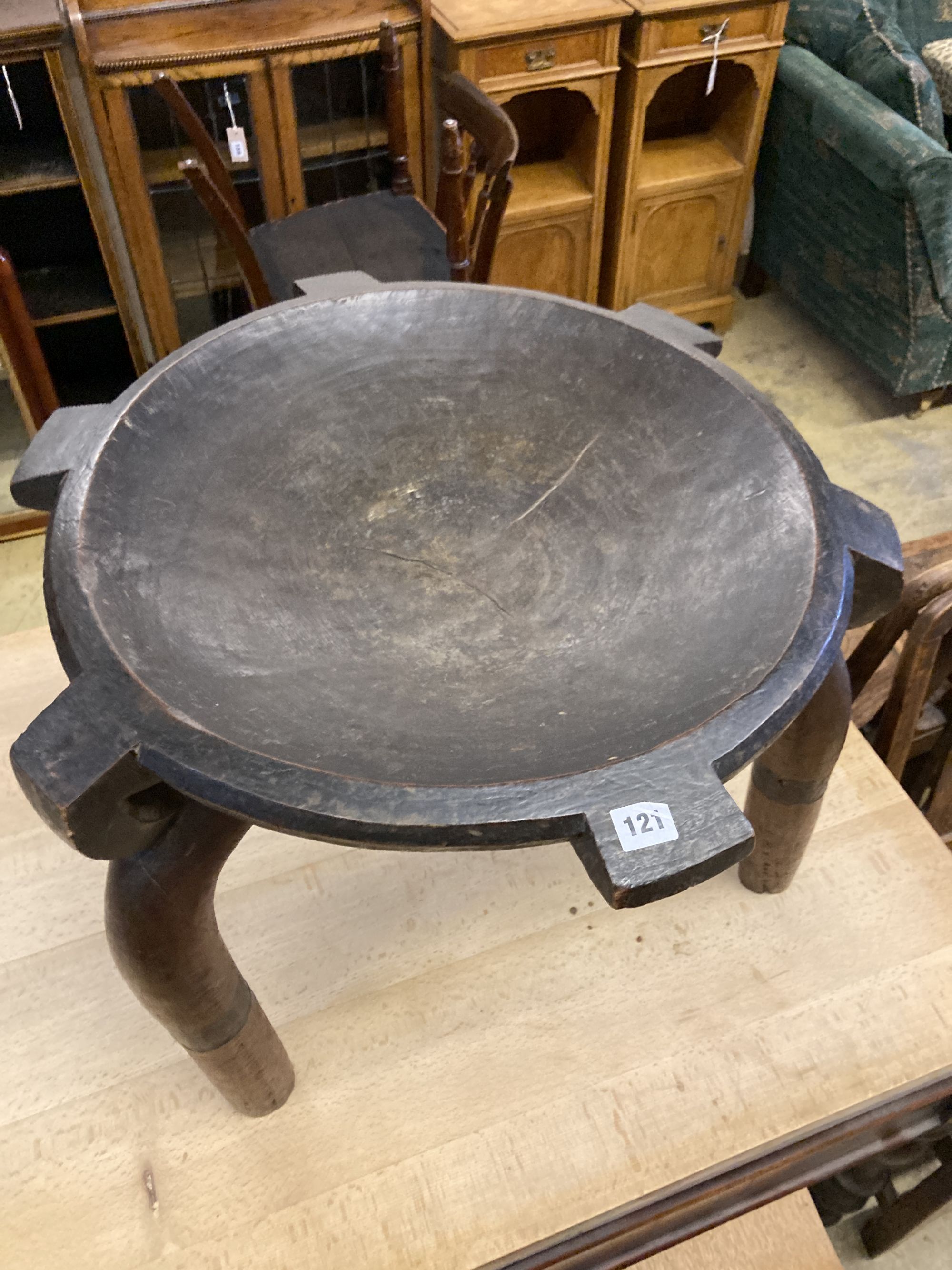 An African carved hardwood bowl seat three legged stool, diameter 60cm, height 52cm